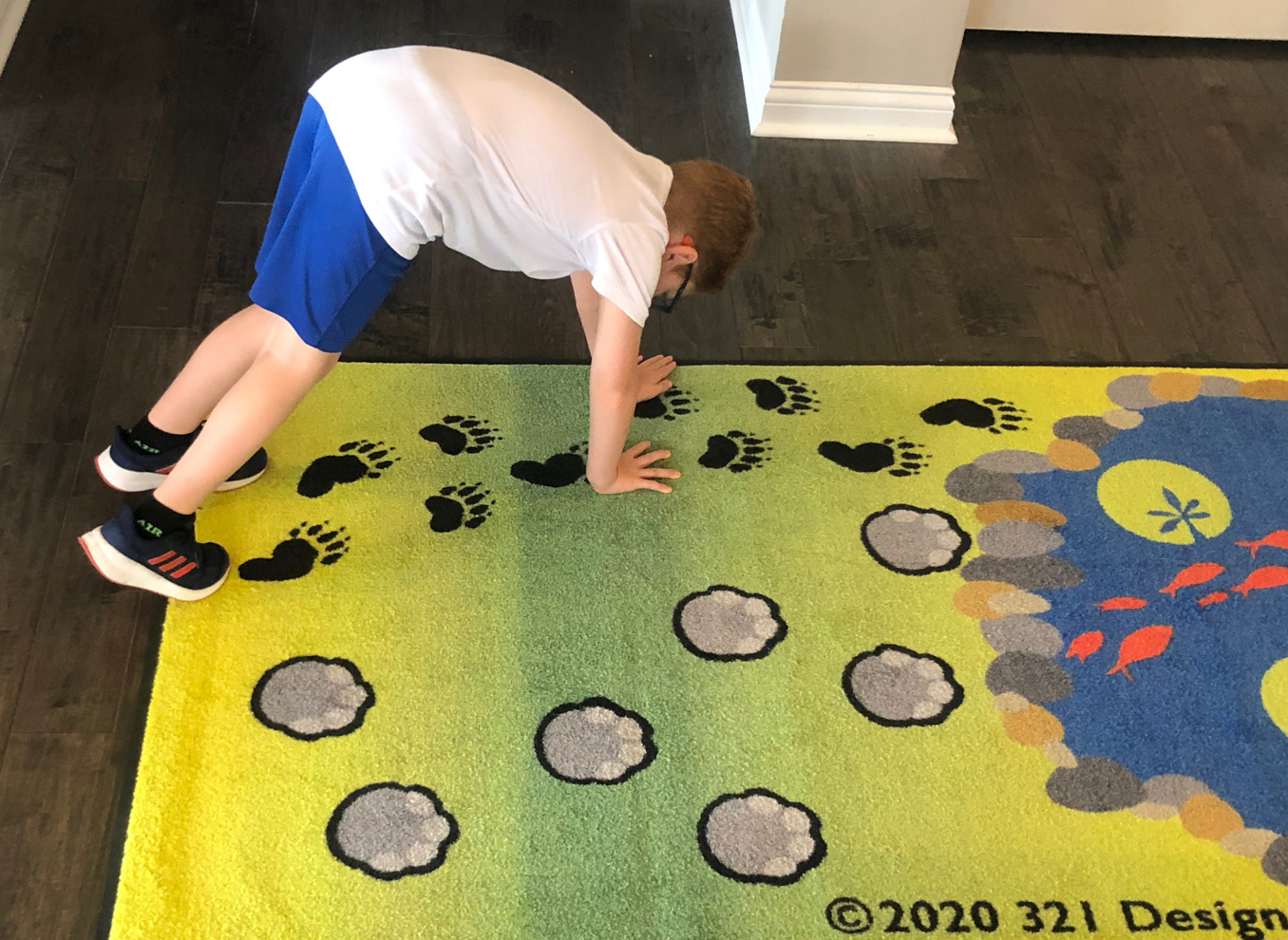 boy doing bear walk on bear footprints sensory path